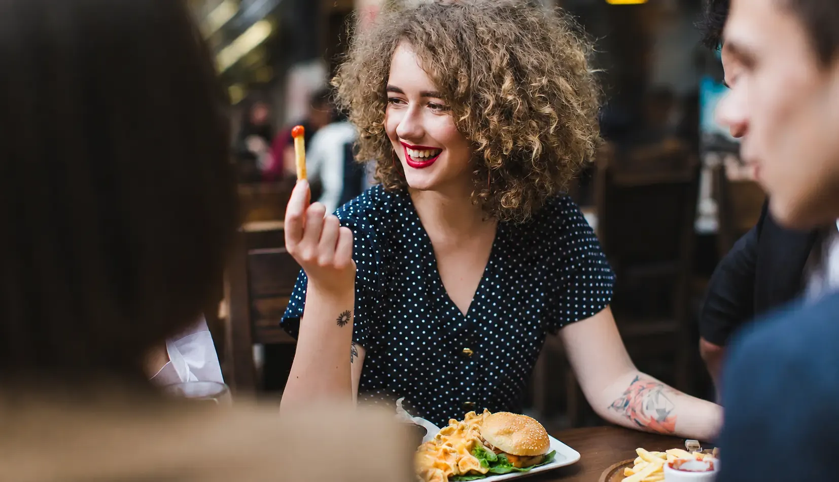 Femme souriante tenant une frite